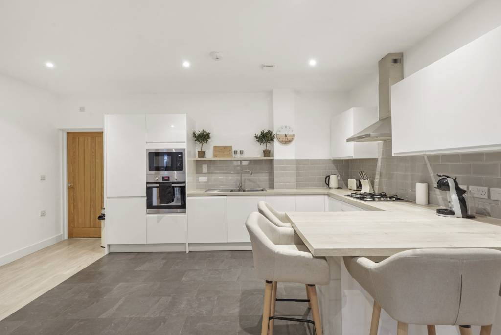 Open wood-panneled kitchen with island in Manchester