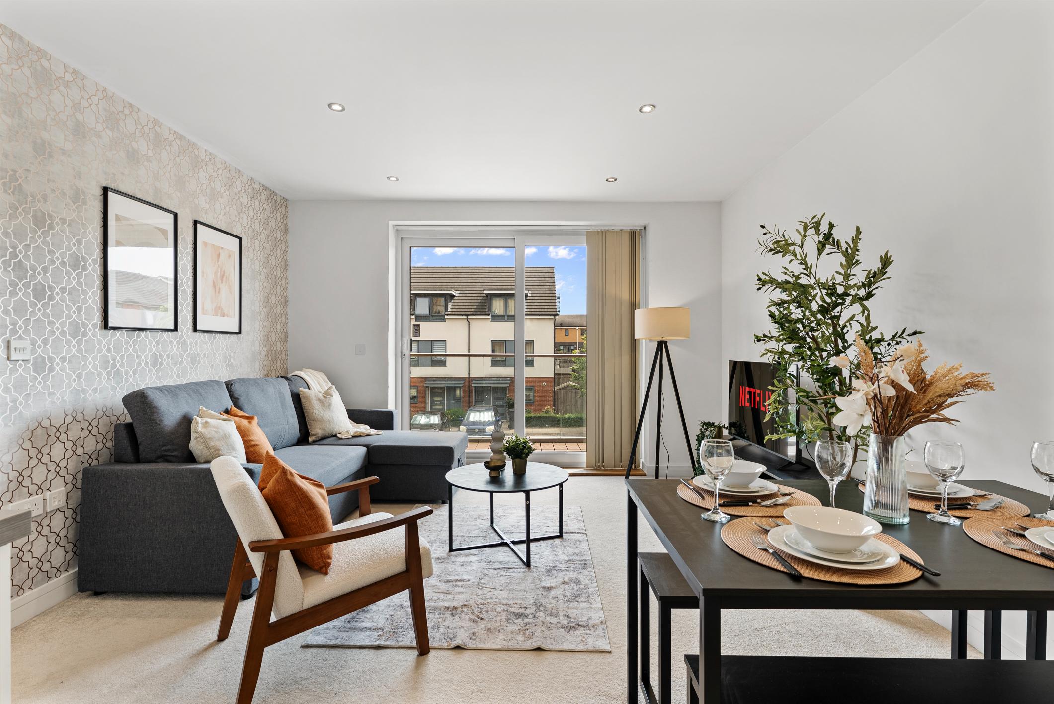 Bright open-plan living and dining room with a grey sofa
